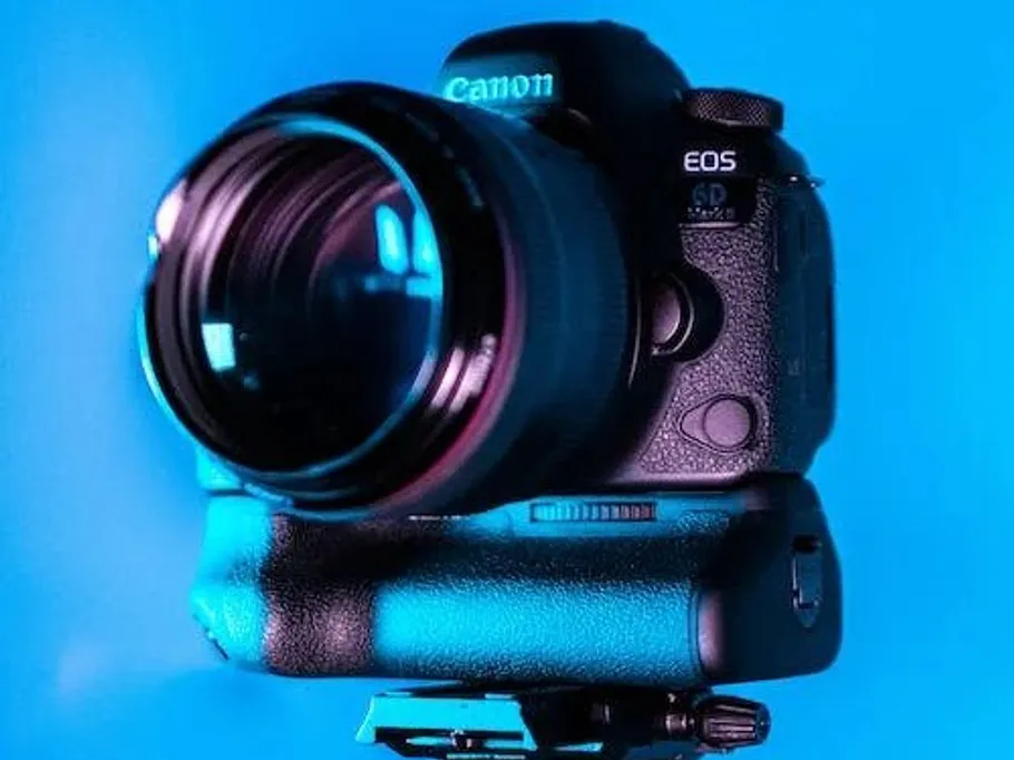 Camera on stand, illuminated in a blue background.