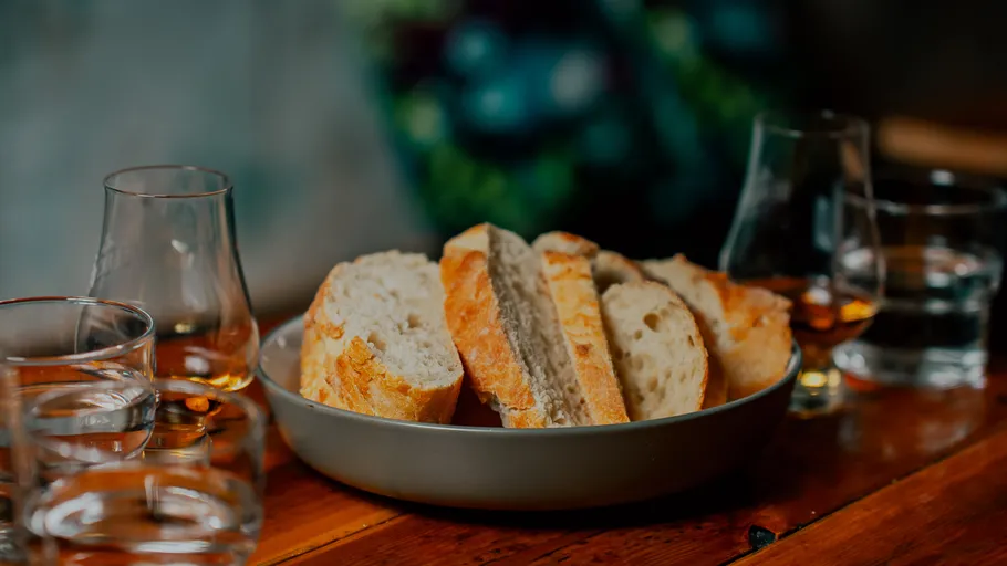 Brotscheiben in Schüssel mit Gläsern auf Tisch.