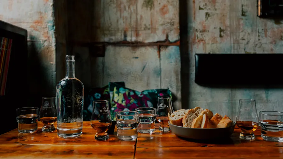 Table with drinks and bread in rustic setting.