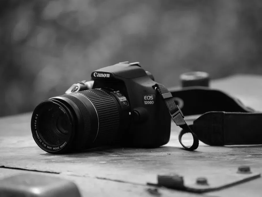 Digital camera is lying on a table in black and white.