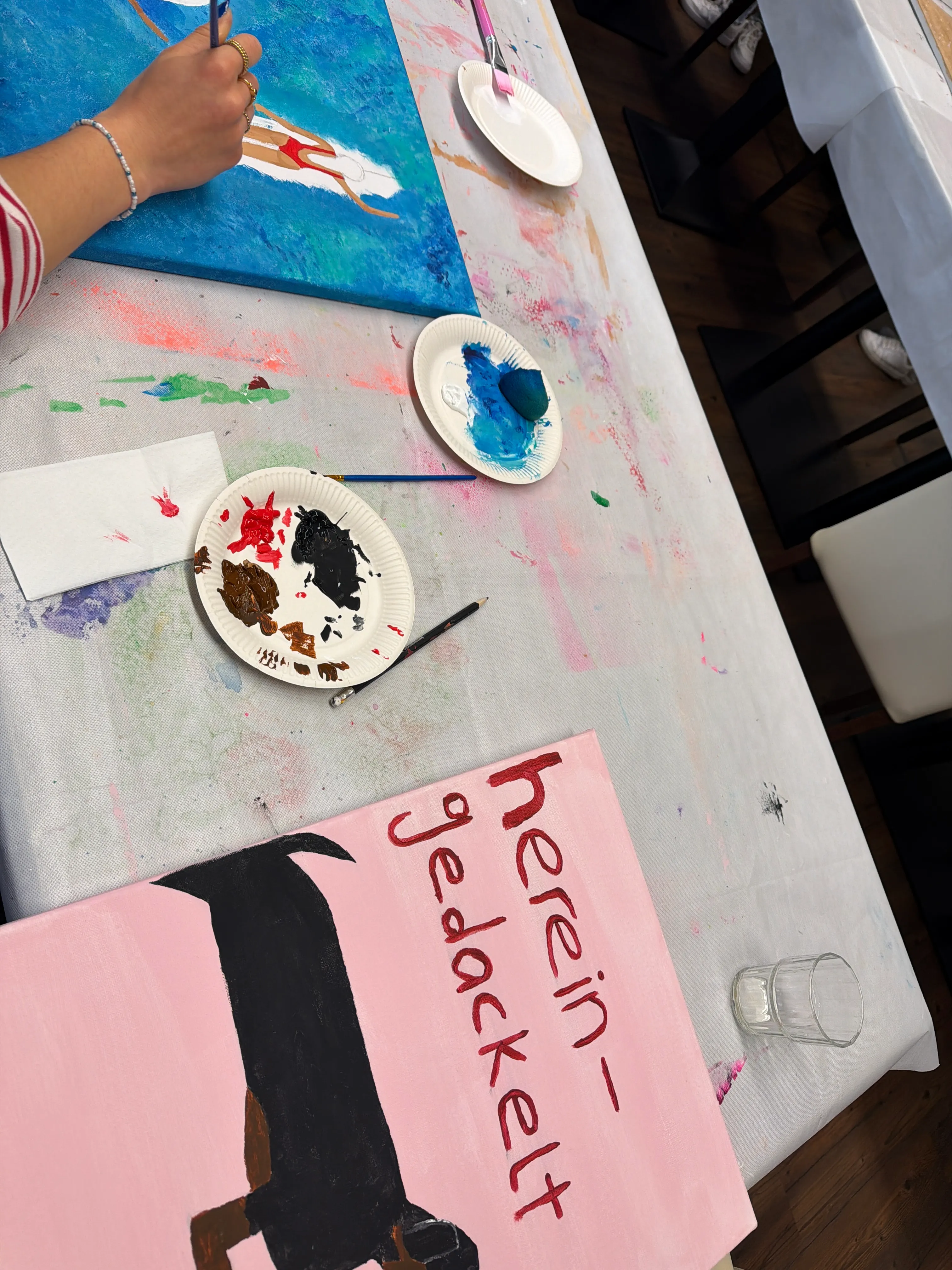 Person malt auf Leinwand in einem Workshop.