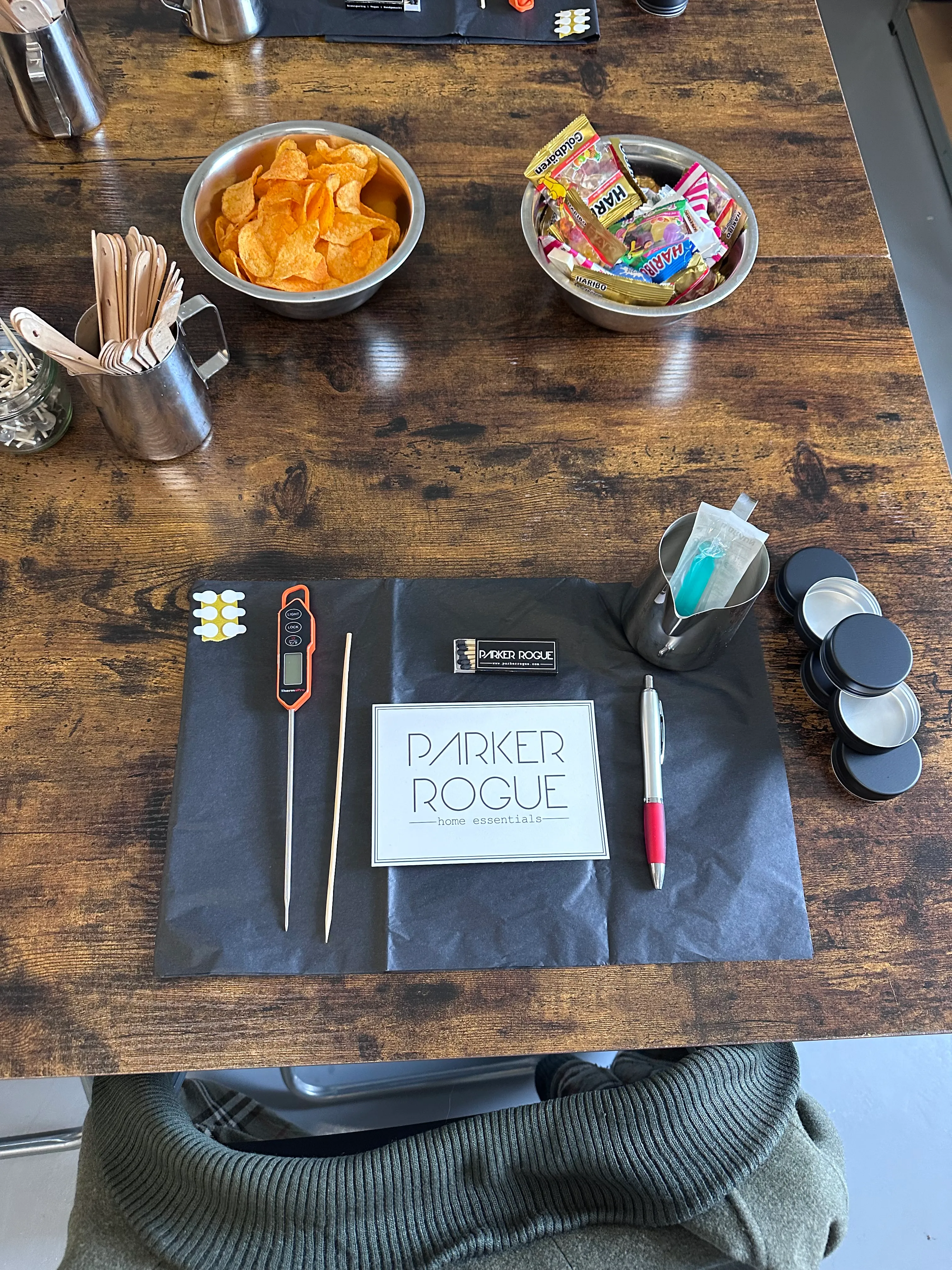 Wooden table with snacks and writing tools.