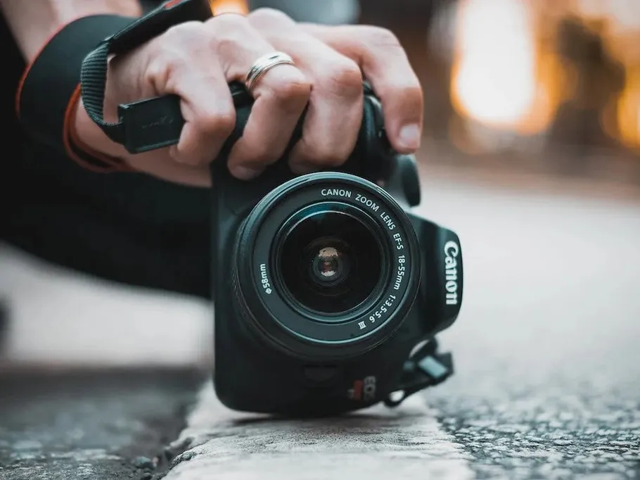 Camera is held to take pictures of something outdoors.