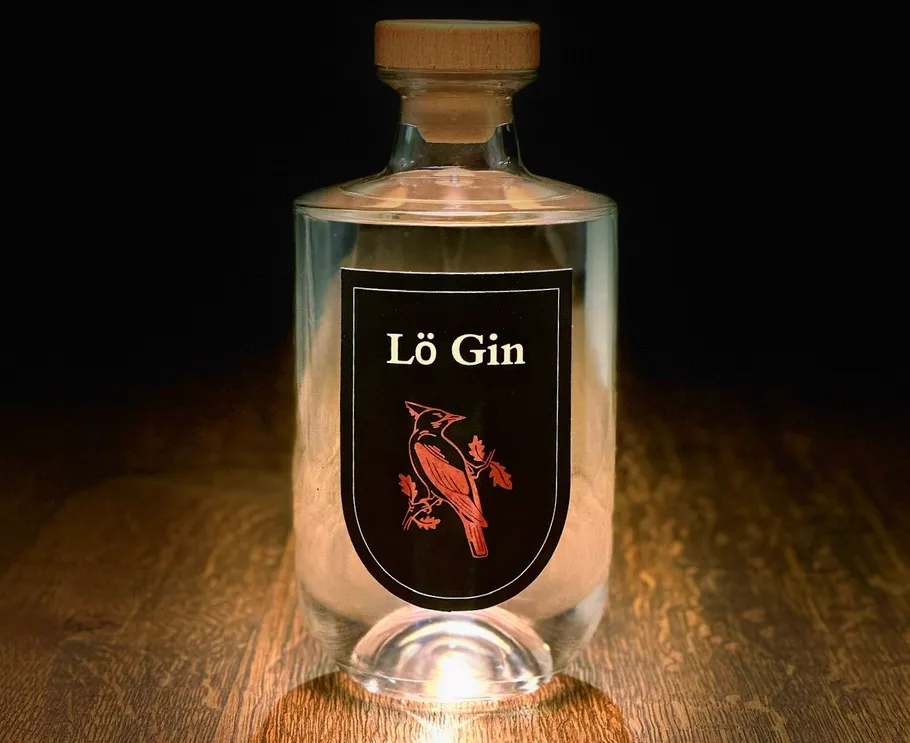 Glasflasche mit Lö Gin Etikett auf Tisch.