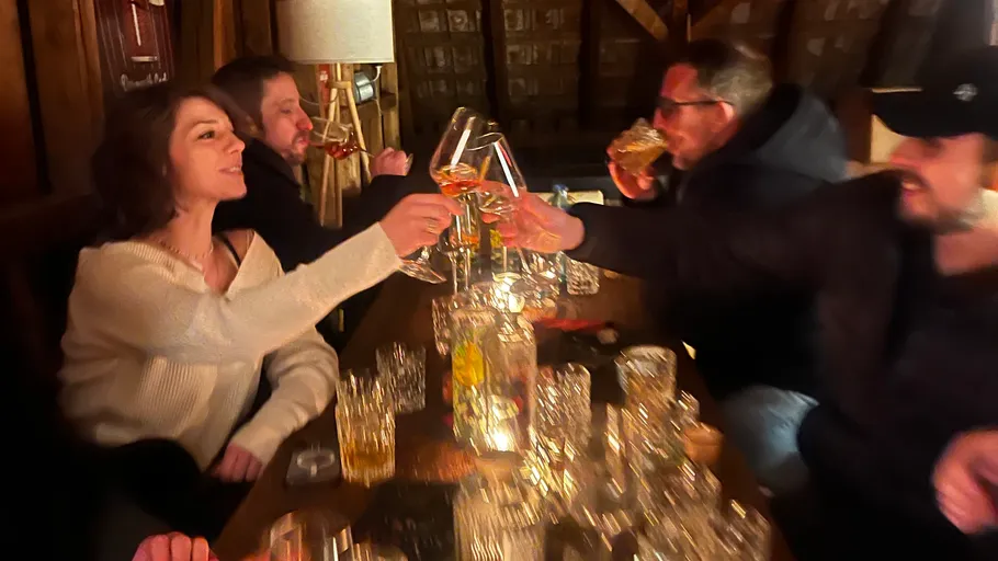 Leute stoßen mit Getränken in gemütlicher Umgebung an.