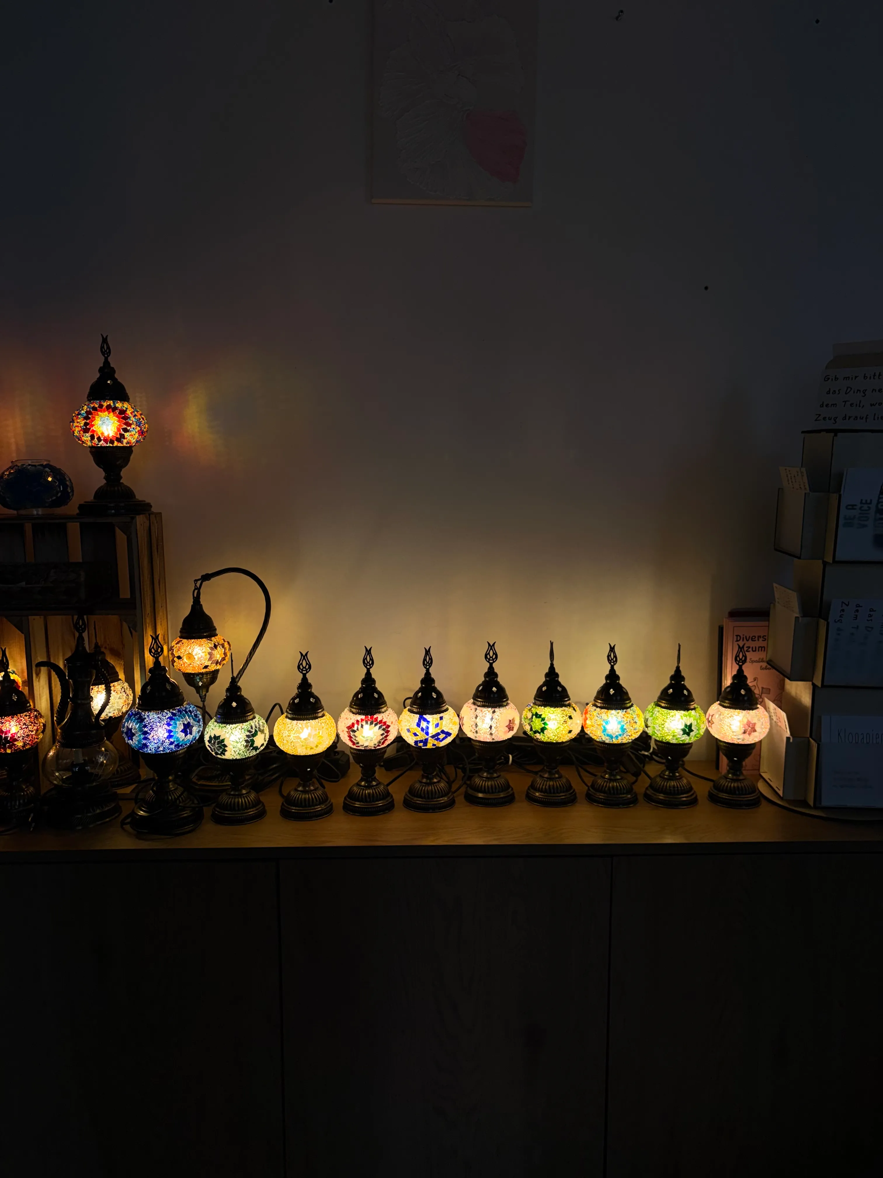 Bunte Mosaiklampen beleuchten einen dunklen Raum.