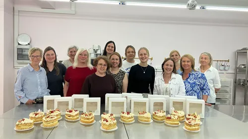 Gruppe von Frauen mit Kuchen in einer Bäckerei.
