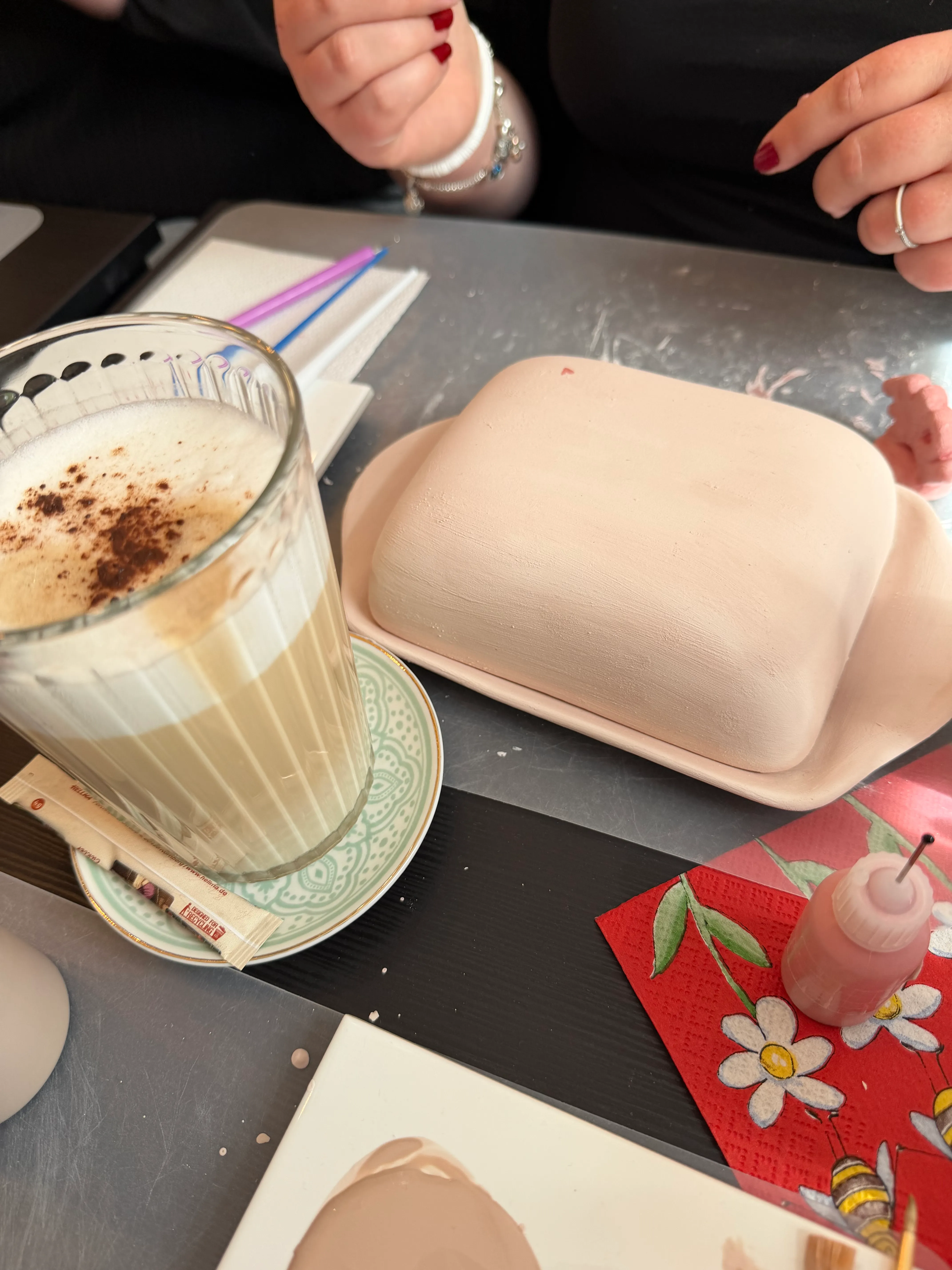 Hände bereiten Kunsthandwerk mit Kaffee auf Tisch vor.