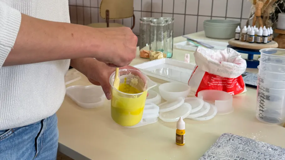 Person mischt gelbe Flüssigkeit in einem Becher.