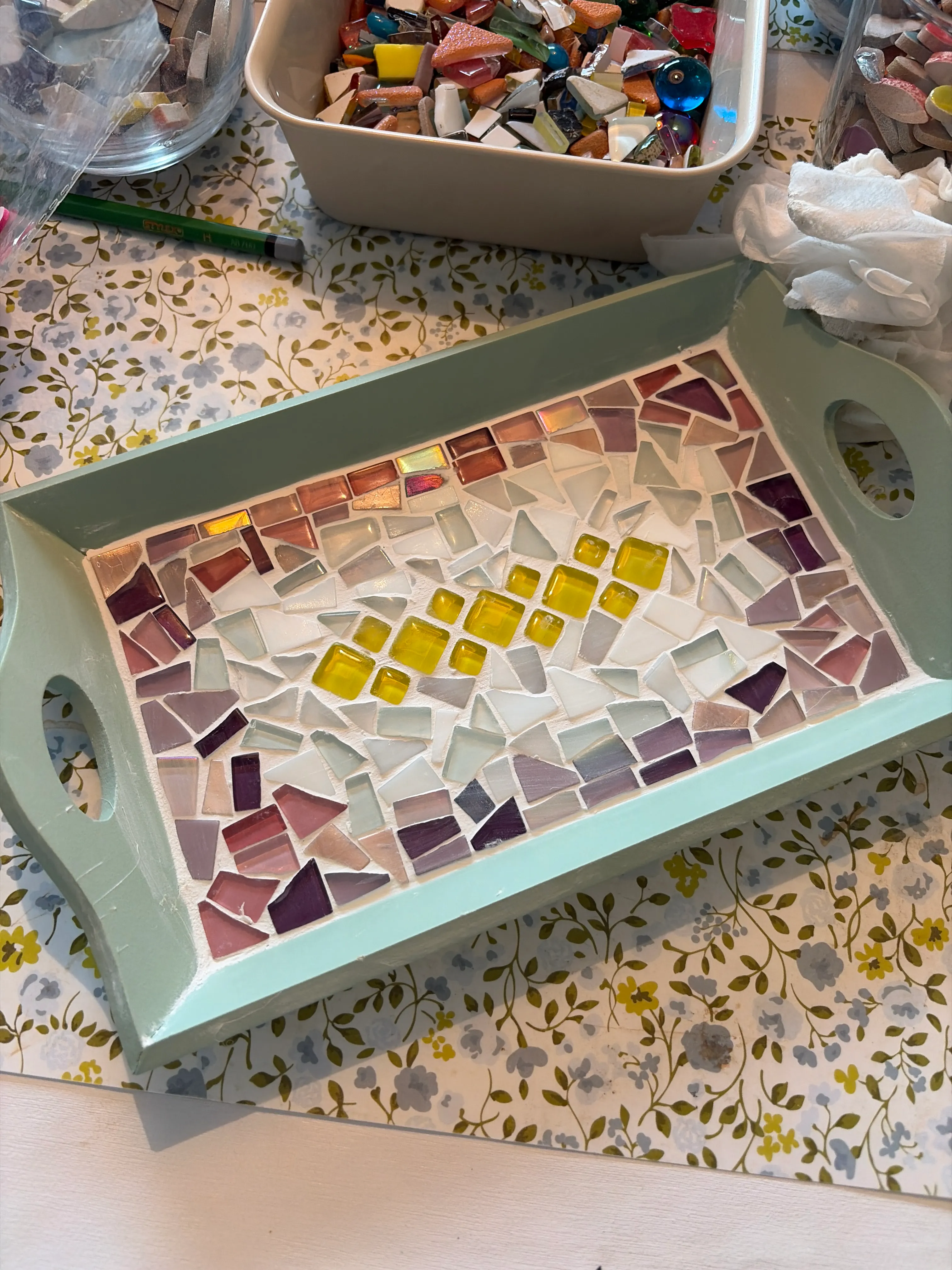 Mosaikverzierter Tablett auf Blumendecke.