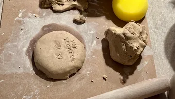Ton mit Abdruck auf Holzbrett.