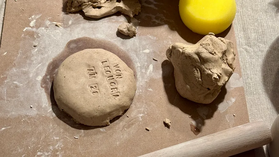 Ton mit Abdruck auf Holzbrett.