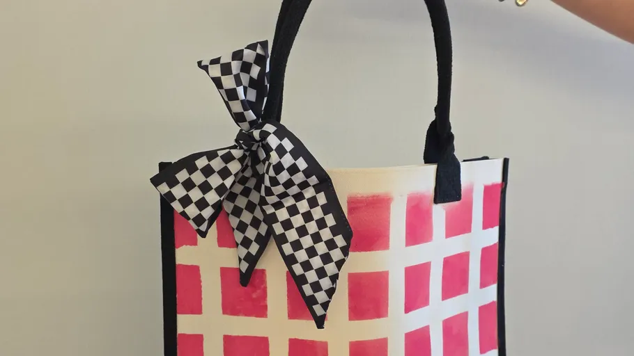 Checkered bow on red patterned handbag.