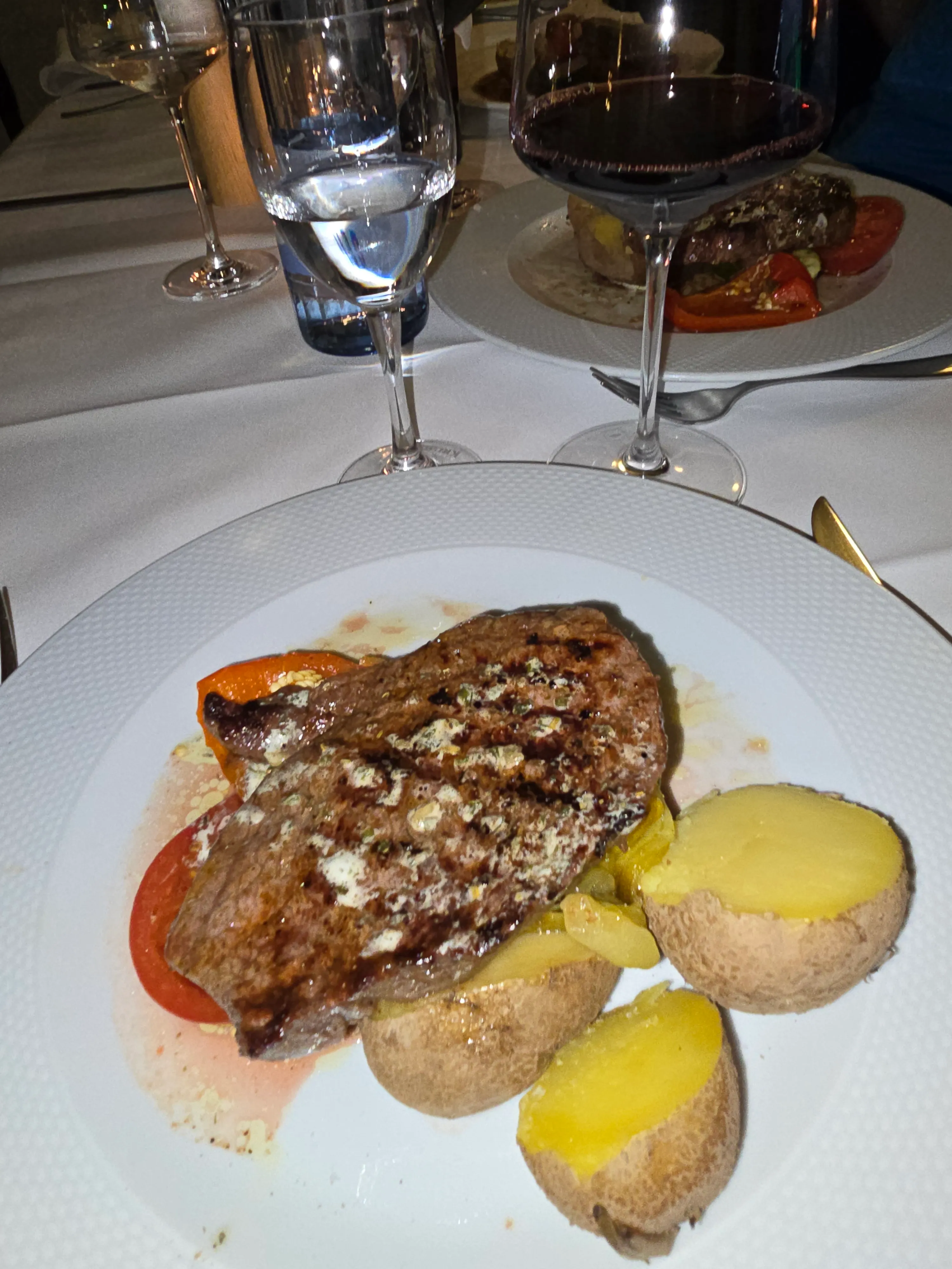 Steak mit Kartoffeln auf weißem Teller.