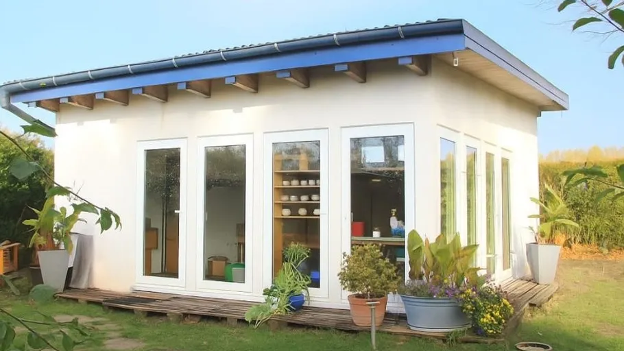 Kleines Gartenstudio mit großen Fenstern.