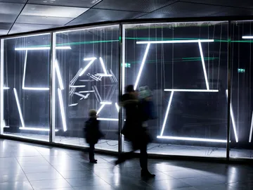 Glowing lines move as passers-by pass by.