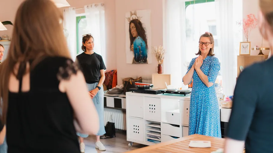 Women standing and talking in a home setting.