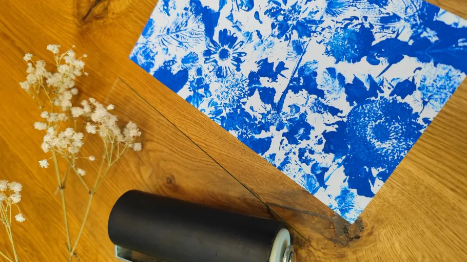 Blue floral print, paint roller, wooden table.
