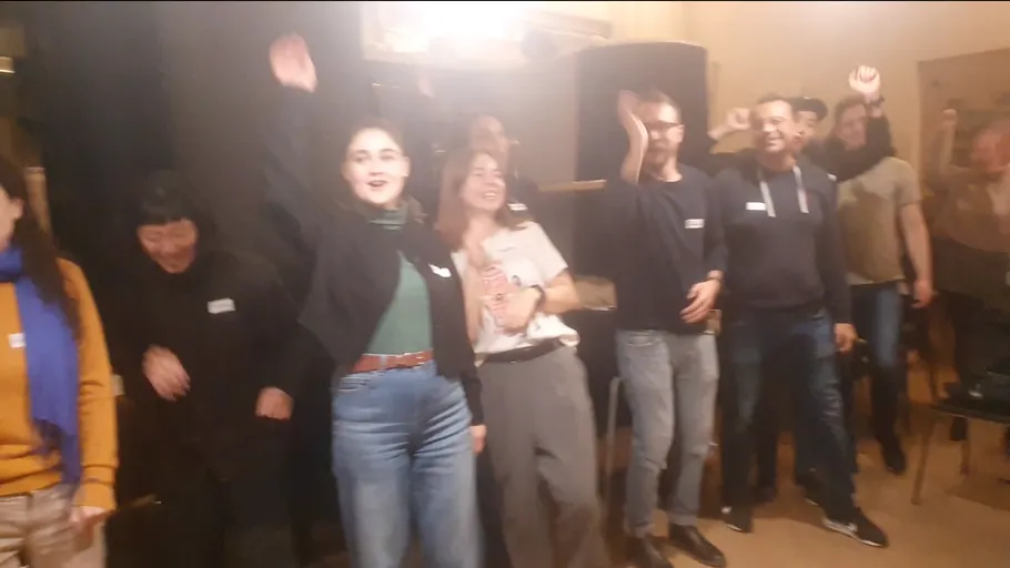 Group celebrating with raised arms inside.