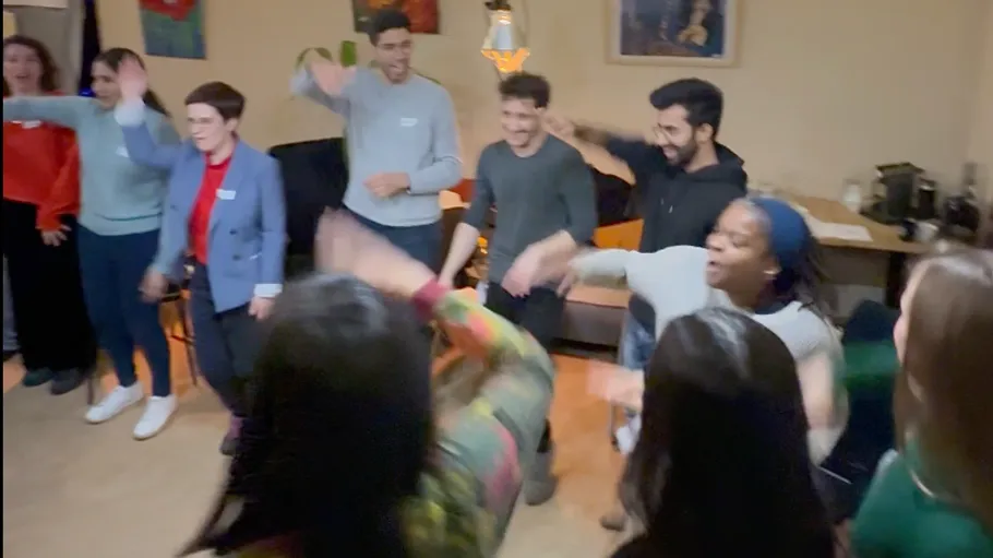 Group of people laughing and dancing indoors.
