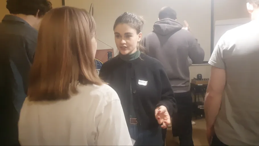 Two people talking at an indoor gathering.