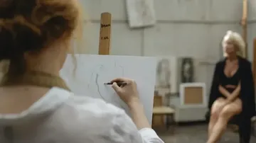 Künstler zeichnet Modell in einem Atelier.