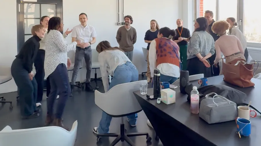 Group laughing in office setting.