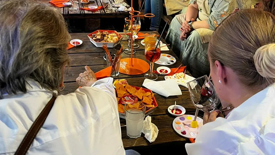 Leute genießen Getränke und Snacks am Tisch.