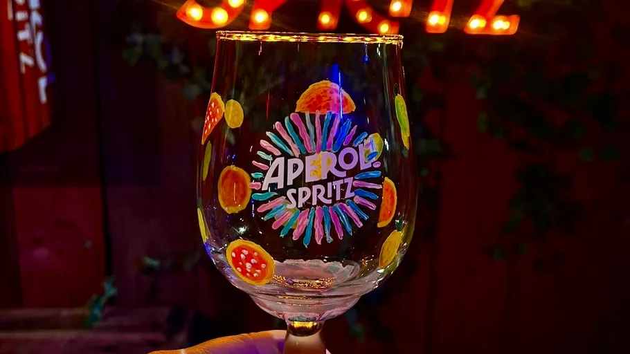 Dekoriertes Glas vor hellen Lichtern gehalten.