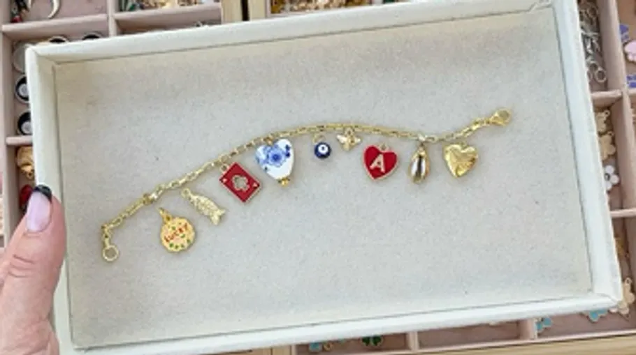 Charme-Armband mit verschiedenen Anhängern in einer Schachtel.