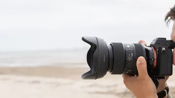 Kamera mit Objektiv auf Strand gerichtet.