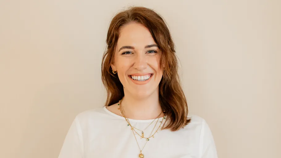 Smiling woman wearing a white shirt indoors.