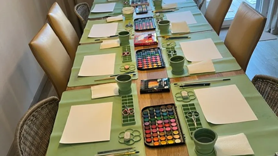 Art supplies arranged on large table.