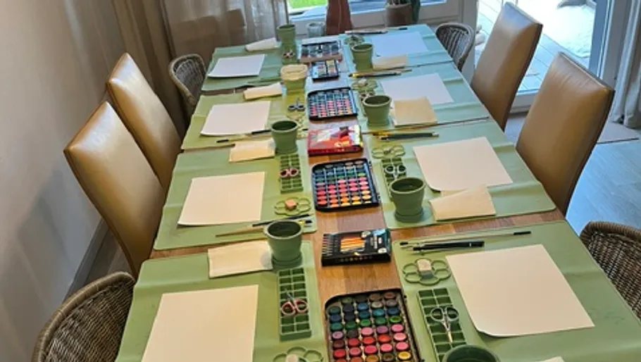Art supplies arranged on a dining table.