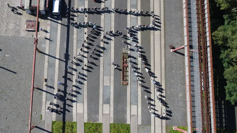 Menschen bilden Pi-Symbol im Freien, Luftaufnahme.