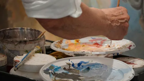 Künstler mischt Farben auf einer Palette.