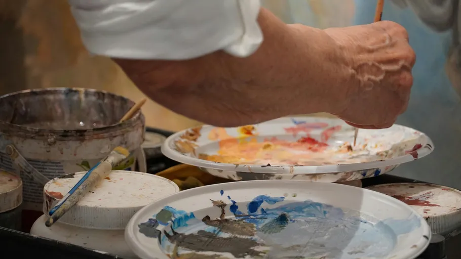 Künstler mischt Farben auf einer Palette.