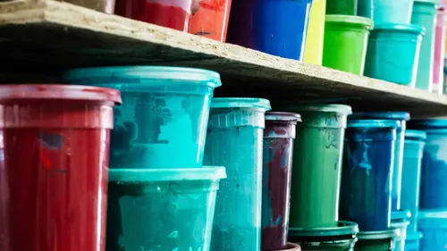 Colorful paint containers arranged on shelves.
