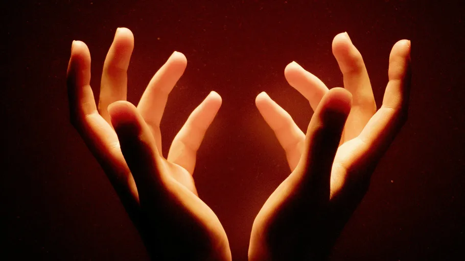 Hands raised upward against red background.