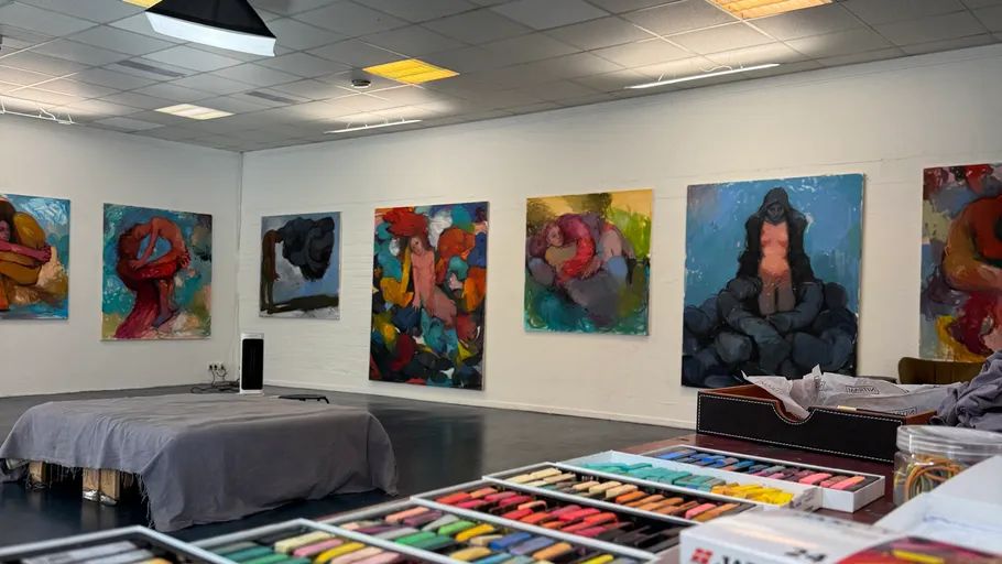 Kunstgalerie mit bunten Gemälden an der Wand.