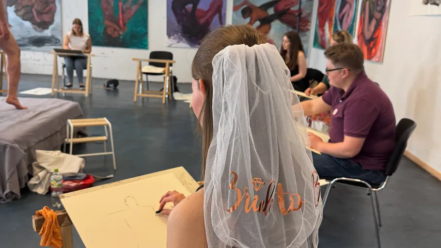 Braut zeichnet im Kunstkurs mit Freunden.