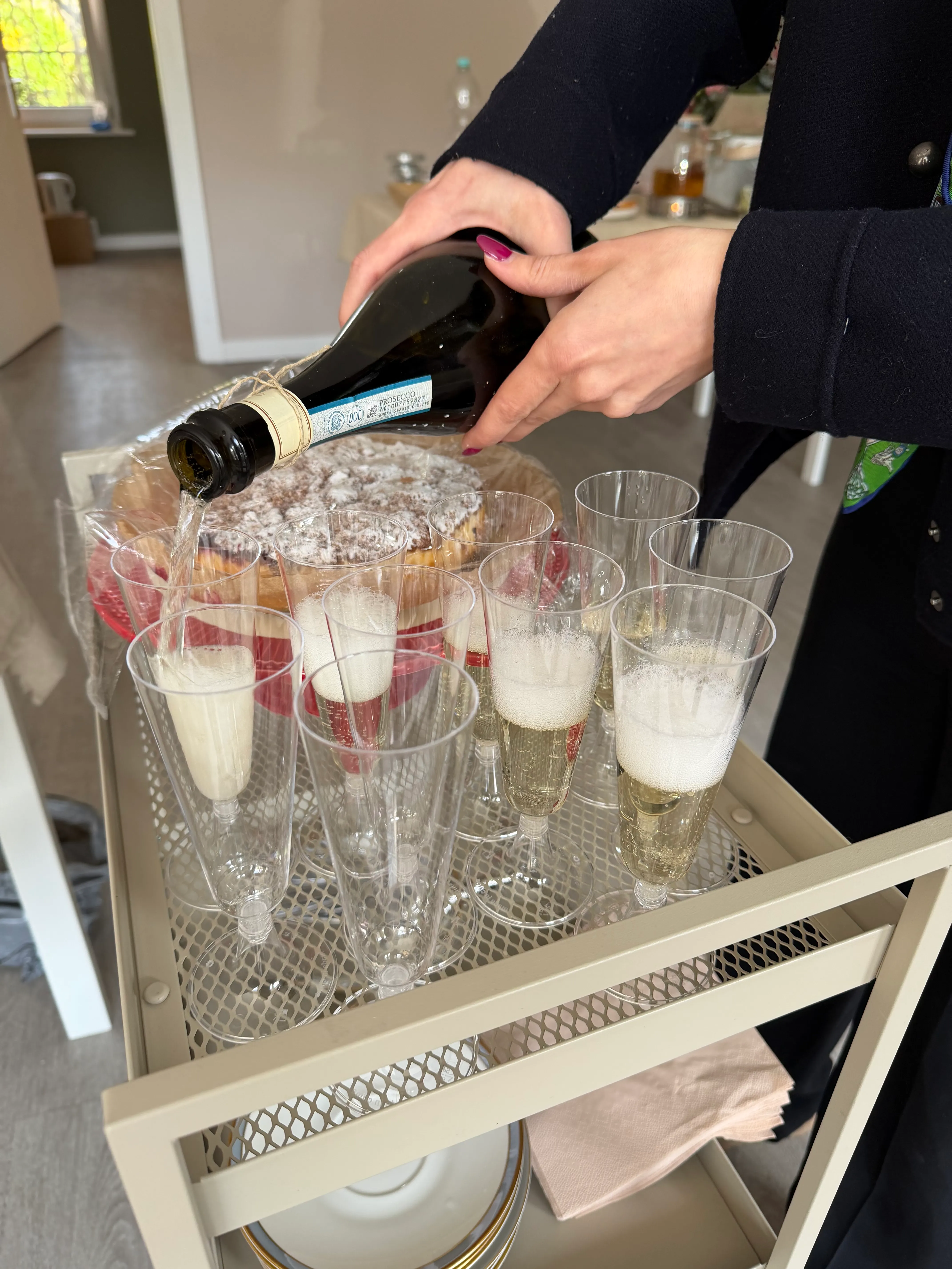 Hände gießen Champagner in Gläser auf Wagen.
