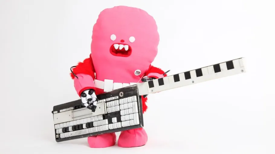 Pinkes Wesen hält Keyboard-Gitarre im Studio.