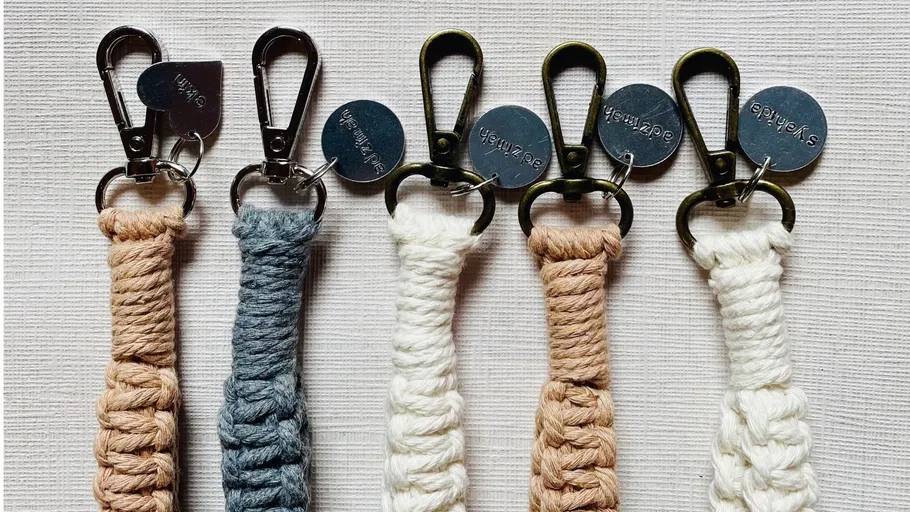 Five woven keychains with metal clasps displayed.