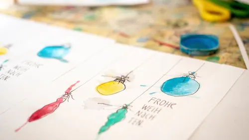 Colorful hand-painted Christmas cards on table.