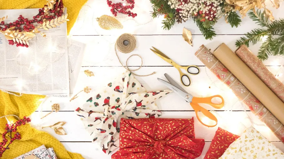 Gift wrapping tools and decorations on a table.