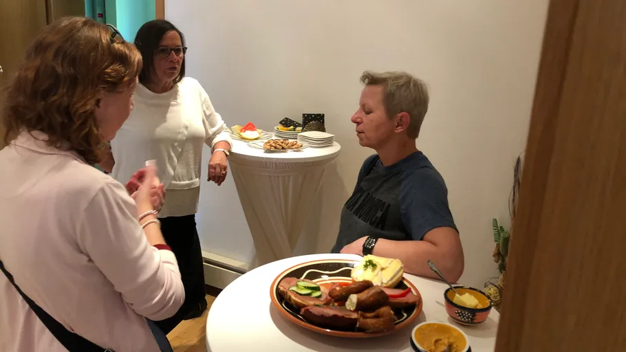 Group of women conversing near a food table.