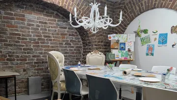 Art studio with brick walls and chandelier.