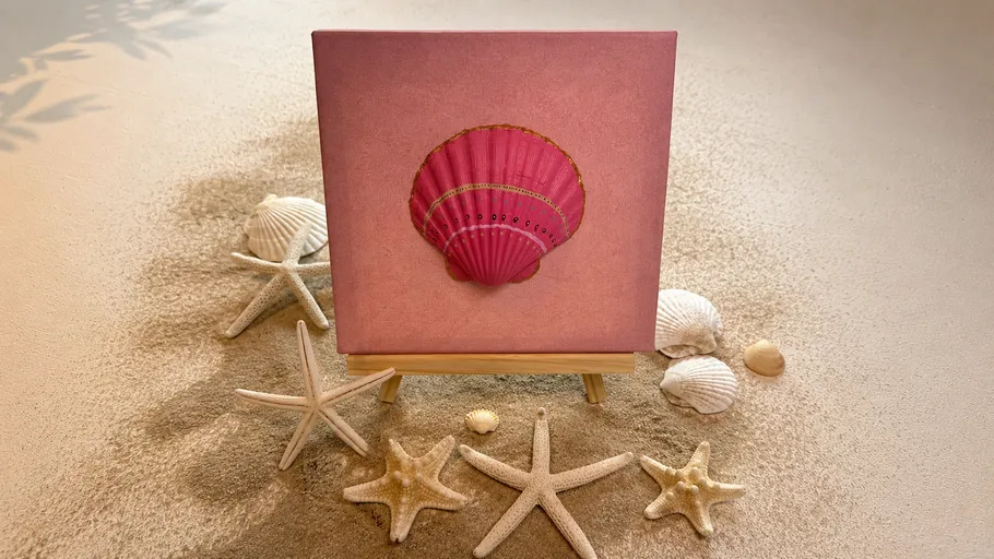 Rosa Muschelbild auf Sand mit Muscheln umgeben.