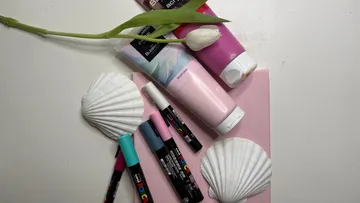 Kunstbedarf mit Tulpe und Muscheln arrangiert.